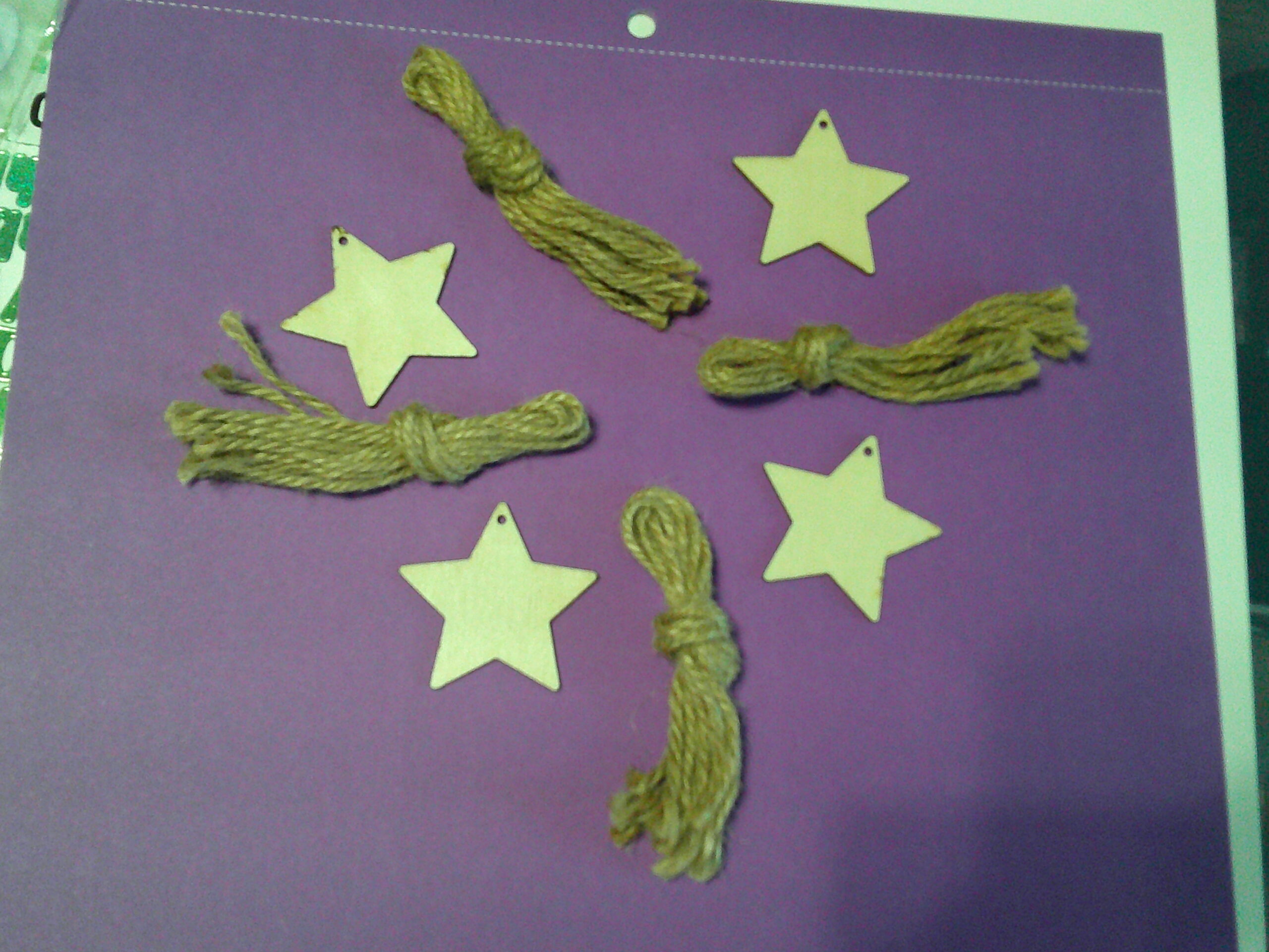 Laser creations craft photo with wooden star cutouts and twine on a purple background